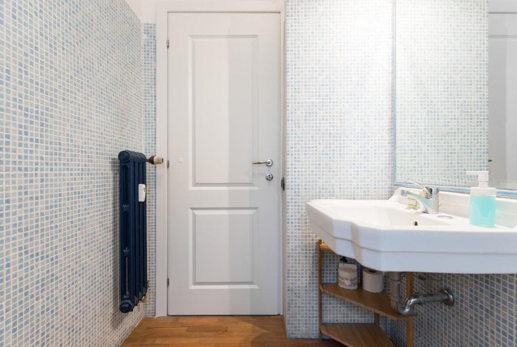 Washbasin and mirror against the blue mosaic wall