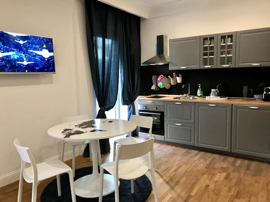 Grey fitted kitchen and round dining table with white chairs