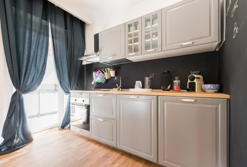 Kitchen with oven, hob, kettle and coffee machine, French door to the balcony