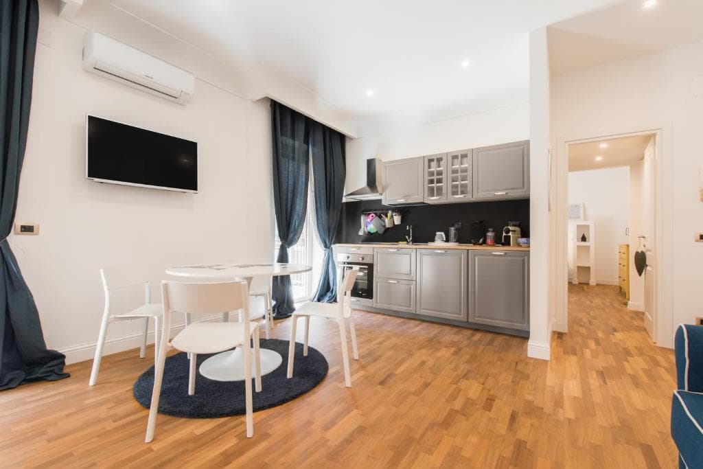 Living area with air conditioning, flat-screen TV and dining table on parquet