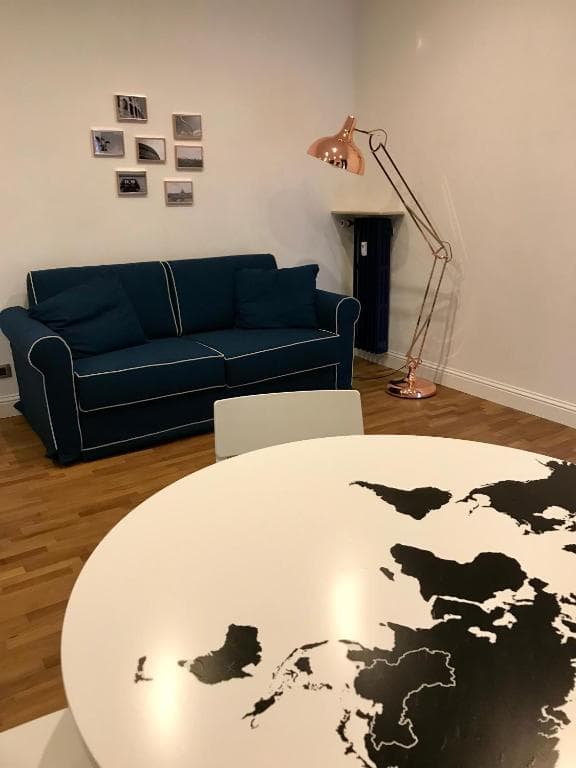 Dining table with world-map top, blue sofa behind